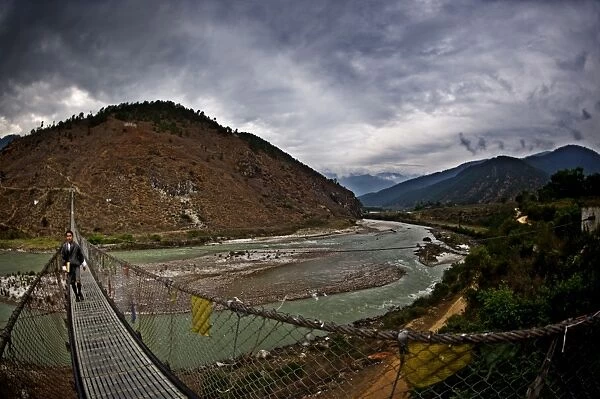 A student crosses Bhutans longest suspension bridge, Panakha, Bhutan