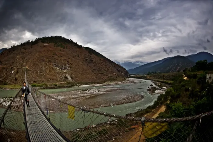 Framed Print : A student crosses Bhutans longest suspension bridge, Panakha, Bhutan Framed Print : A student crosses Bhutans longest suspension bridge, Panakha, Bhutan