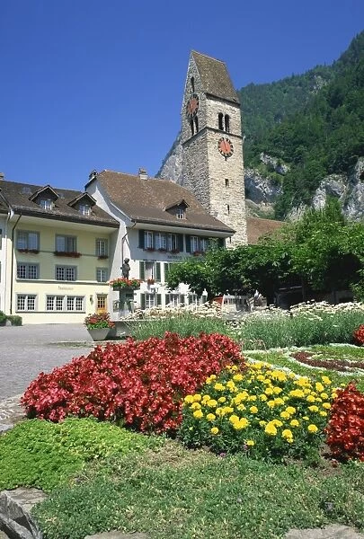 Summer flowers in front of houses and the clock tower