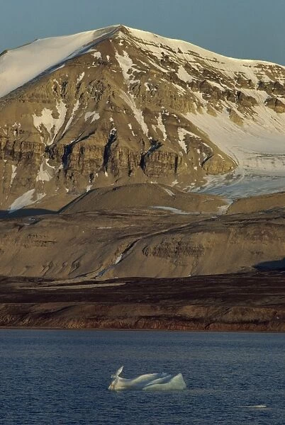 Summer shows cliff faces, and small iceberg, Kongsfjorden, Svalbard, Arctic