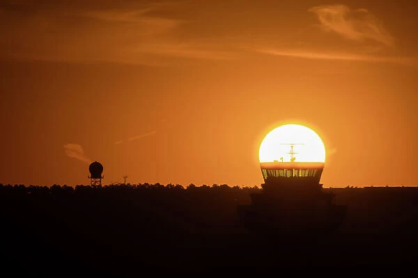 The sun aligned at sunrise with an airport control tower, Spain, Europe