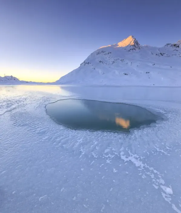 Framed Print : The sun illuminating a peak surrounding the frozen Lago Bianco by Bernina, reflecting in a pool in the center of the lake, Bernina Pass, Graubunden, Swiss Alps, Switzerland, Europe Framed Print : The sun illuminating a peak surrounding the frozen Lago Bianco by Bernina, reflecting in a pool in the center of the lake, Bernina Pass, Graubunden, Swiss Alps, Switzerland, Europe