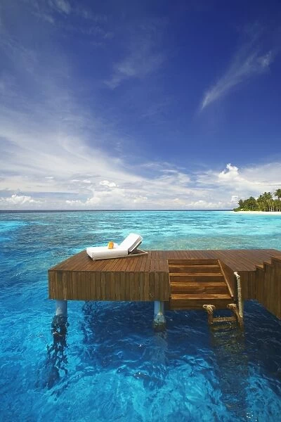 Sun lounger and jetty in blue lagoon on tropical island, Maldives, Indian Ocean, Asia