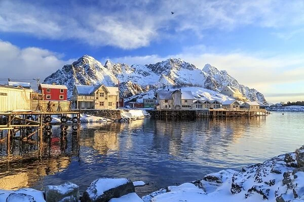 The sun painting the houses overlooking the port of Henningsvaer early in the morning, Lofoten Islands, Arctic, Norway, Scandinavia, Europe