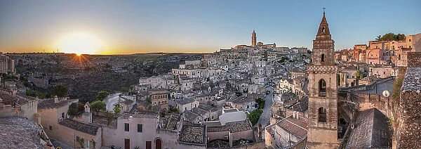 Sun rising over the canyon and Sassi di Matera old town with the campanile of the church of Saint Peter Barisano, UNESCO World Heritage Site, Matera, Basilicata, Italy, Europe