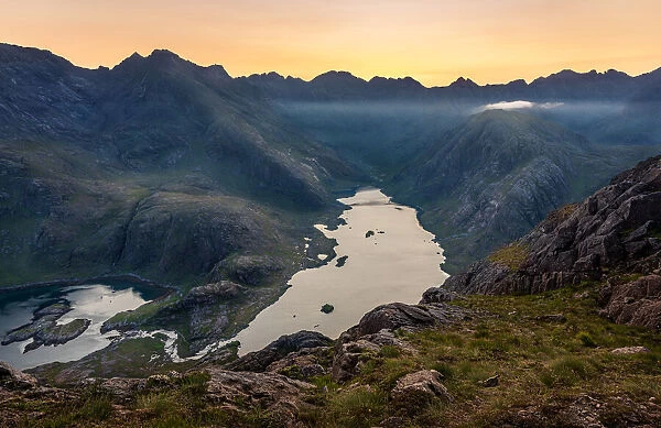 The sun setting behind the Black Cuillin Ridge with the remote Loch Coruisk in the glen