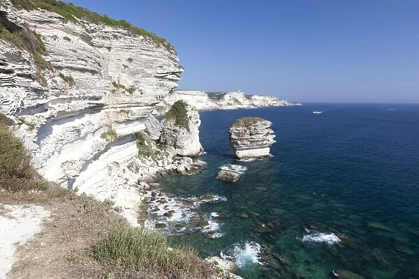 Sun shines on the white limestone cliffs framed by the turquoise sea, Bonifacio, Corsica