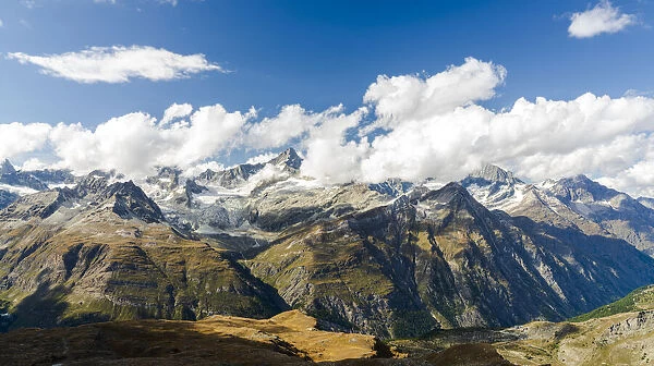 Sun shining over the Zinalrothorn mountain peak through clouds, Valais Canton, Swiss Alps