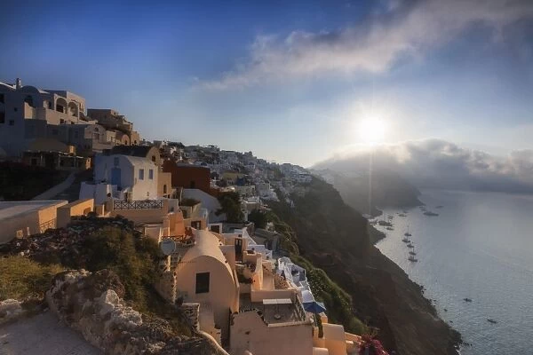 Sunbeam through the clouds over the Aegean Sea seen from the typical village of Oia