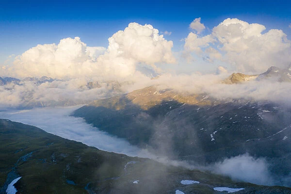 Sunlight over mountains in the fog, aerial view, Furka Pass, Canton Uri, Switzerland
