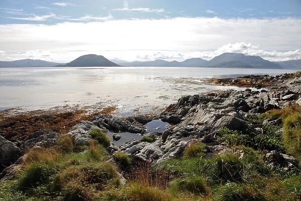 Sunlit rocks and foreshore, Helgoy, Kvalsund, Troms, North Norway, Norway, Scandinavia, Europe