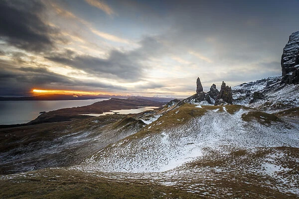 Sunrise breaks through on to a wintery landscape at the Old Man of Storr, Isle of Skye