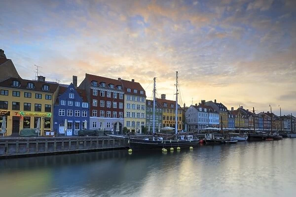 Sunrise on the colourful facades along the harbour in the district of Nyhavn, Copenhagen