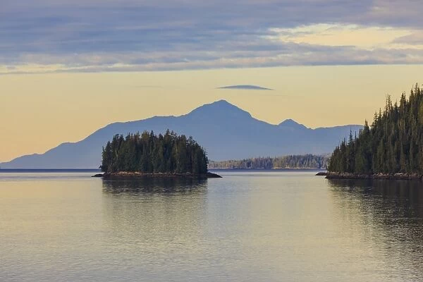 Sunrise, entering the Misty Fjords National Monument, islands, forest and distant mountains