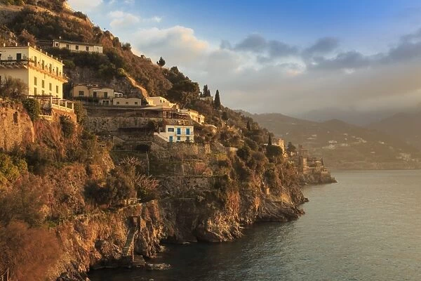 Sunrise lights up villas, misty dawn on the Amalfi Coast, near Atrani in spring