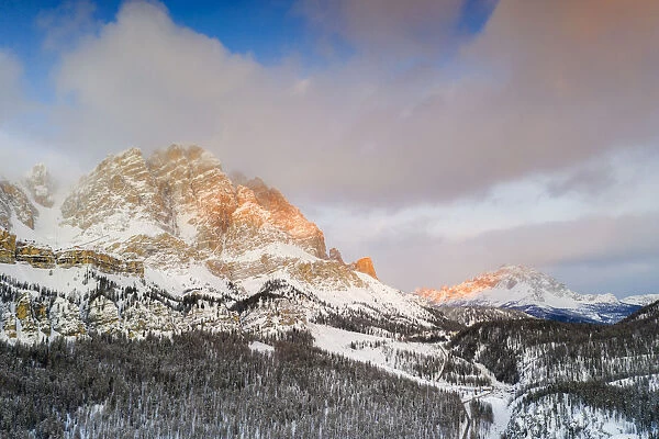 Sunrise over Monte Cristallo and Passo Tre Croci surrounded by snowy woods, Dolomites