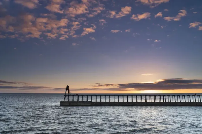Framed Print : Sunrise over the North Sea and Whitby harbour and piers in late summer, Whitby Framed Print : Sunrise over the North Sea and Whitby harbour and piers in late summer, Whitby