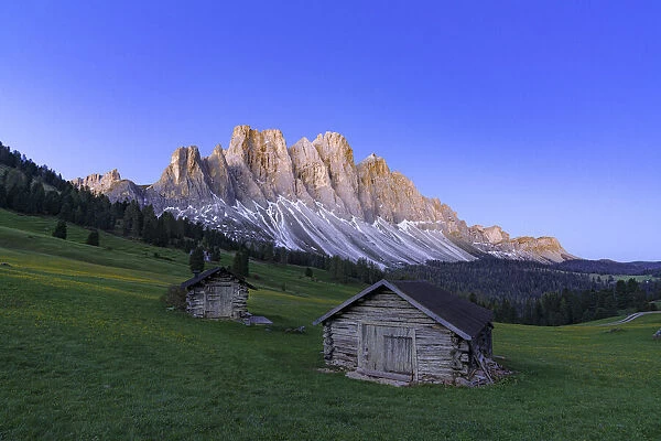 Sunrise over the Odle group and mountain huts in spring, Gampen Alm, Funes Valley, Dolomites, South Tyrol, Italy, Europe