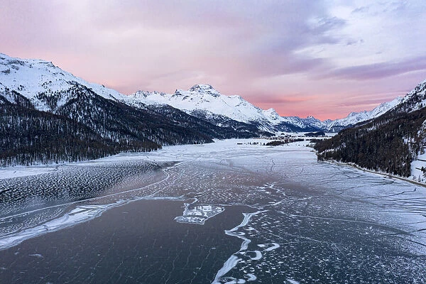 Sunrise on the snowcapped mountains and frozen Lake Silvaplana, aerial view, Maloja