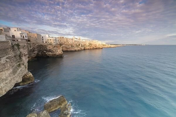 Sunrise on the turquoise sea framed by old town perched on the rocks, Polignano a Mare