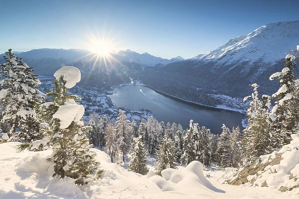 Sunrise over village and Lake of St. Moritz covered with snow, Engadine, Canton of Graubunden
