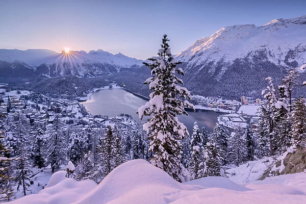 Sunrise over village and Lake of St. Moritz covered with snow, Engadine, Canton of Graubunden