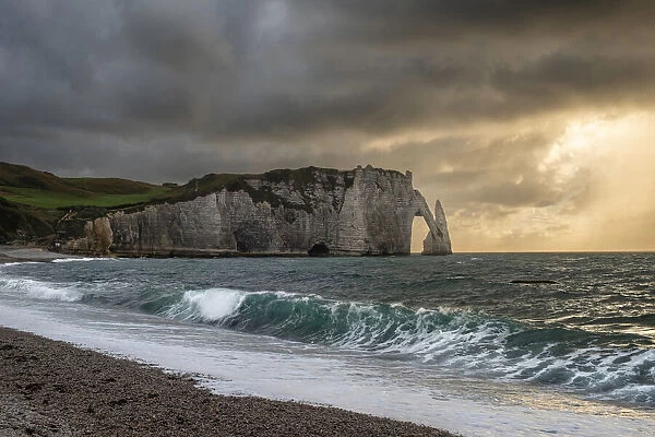 Sunset from the beach of Etretat, over the sea, the cliffs and the natural arch, Etretat, Normandy, France, Europe