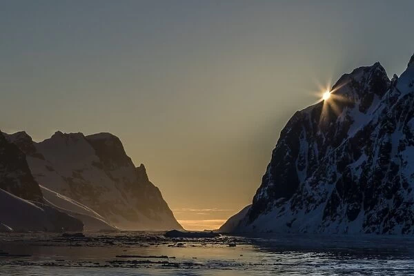 Sunset over Booth Island in the waters of the Lemaire Channel, Antarctica, Polar Regions