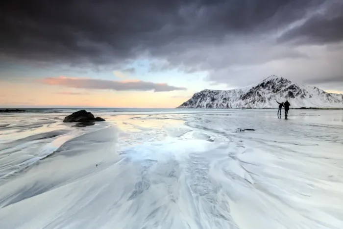 Framed Print : Sunset and hikers on Skagsanden beach surrounded by snow covered mountains, Flakstad Framed Print : Sunset and hikers on Skagsanden beach surrounded by snow covered mountains, Flakstad