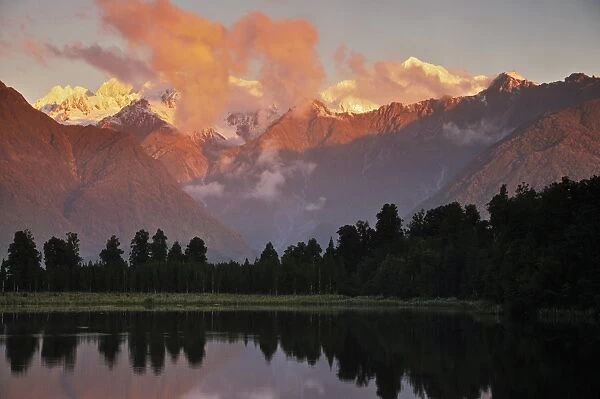 Sunset, Lake Matheson, with Mount Tasman and Mount Cook behind clouds, Westland Tai Poutini National Park, UNESCO World Heritage Site, West Coast, Southern Alps, South Island, New