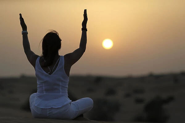 Sunset meditation in the desert at sunset, as concept for religion, faith