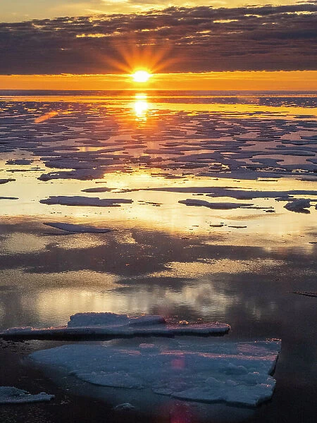 Sunset over melt water pools in the heavy pack ice in McClintock Channel, Northwest Passage, Nunavut, Canada, North America
