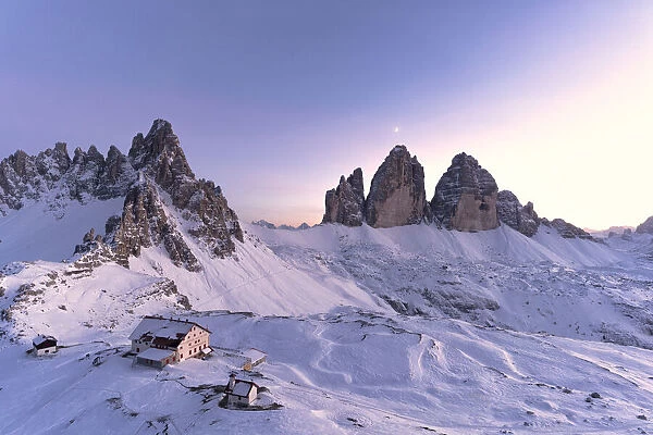 Sunset over Monte Paterno, Tre Cime di Lavaredo and Locatelli hut covered with snow