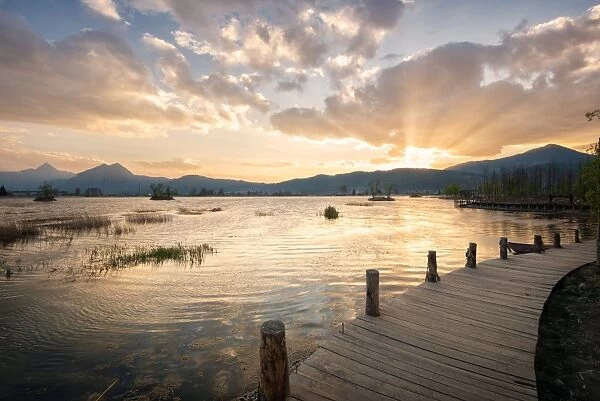 Sunset over mountains, lake and boardwalk in Lijiang, Yunnan, China, Asia