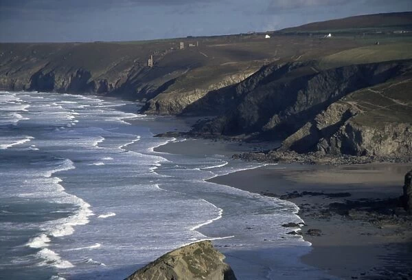 Surf and tin mine chimneys in distance, Porthtowan, Cornwall, England, United Kingdom