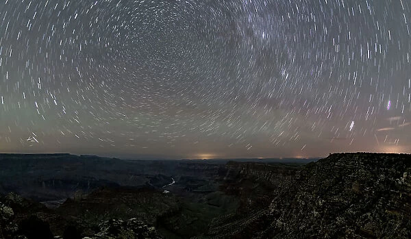 The swirl of stars in the night sky over Grand Canyon South Rim viewed from Navajo Point with the historic Watchtower in the distance on the right, Grand Canyon National Park, UNESCO World Heritage Site, Arizona, United States of America