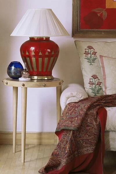 Side table and hand blown glass based lamp beside sofa