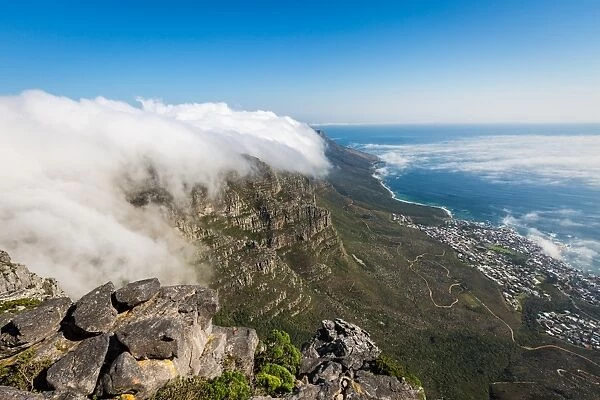 Table Mountain covered in a tablecloth of orographic clouds, Camps Bay below covered in low cloud