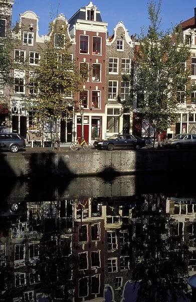 Tall traditional style houses reflected in the water of a canal