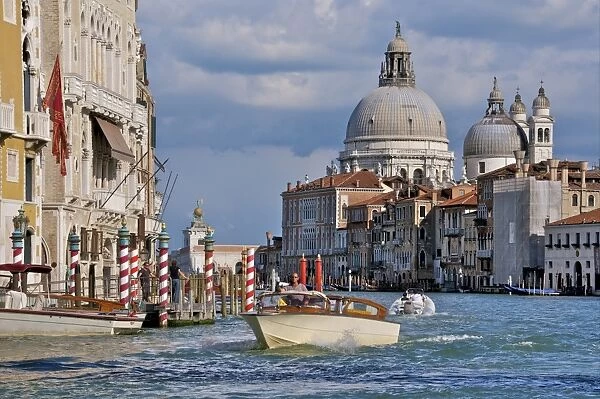 Taxi and boat on Grand Canal with palace facades and Salute church domes, San Marco, Venice, UNESCO World Heritage Site, Veneto, Italy, Europe
