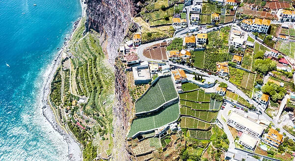 Terraced green fields by the turquoise ocean from above, Camara de Lobos, Madeira island
