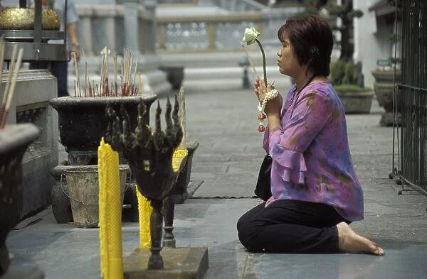 Thai Buddhist woman praying at temple