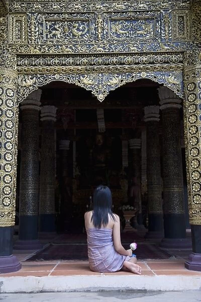 Thai woman praying in Buddhist temple