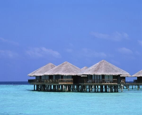 Thatched bungalows over the water in the Maldive Islands, Indian Ocean, Asia