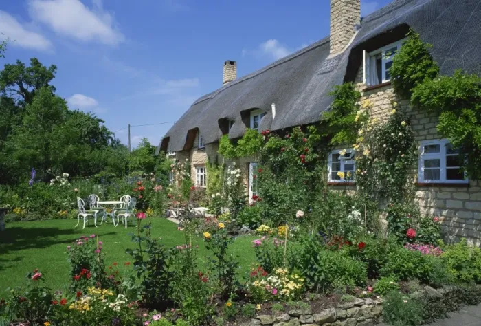 Framed Print : Thatched cottages with roses on the walls and gardens with summer flowers in the Cotswolds Framed Print : Thatched cottages with roses on the walls and gardens with summer flowers in the Cotswolds