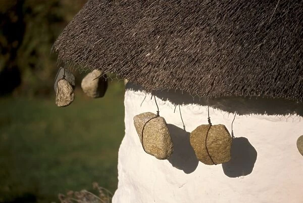 Thatched house with tied stones