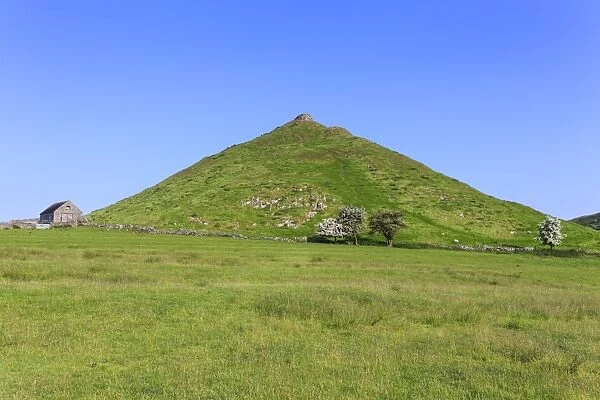 Thorpe Cloud, a conical hill with hawthorns in blossom and barn, Dovedale, Peak District