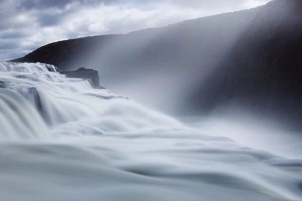 Thundering water at Gullfoss, Icelands most famous waterfall, with sunlight streaming down through the spray, near Reykjavik, Iceland