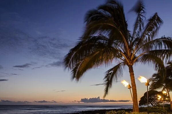 Tiki torches at sunset on Poipu Beach, Kauai, Hawaii, United States of America, Pacific