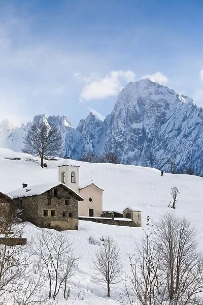 The tiny village of Daloo in Valchiavenna, with its bell tower and church, after a heavy snowfall, Lombardy, Italy, Europe